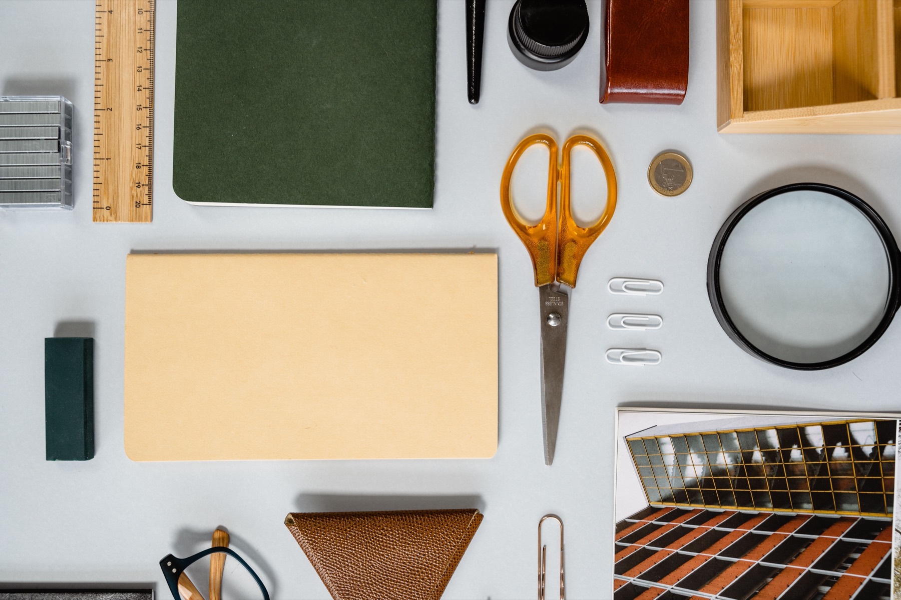 Notebooks, scissors and desk supplies laid out on a white table