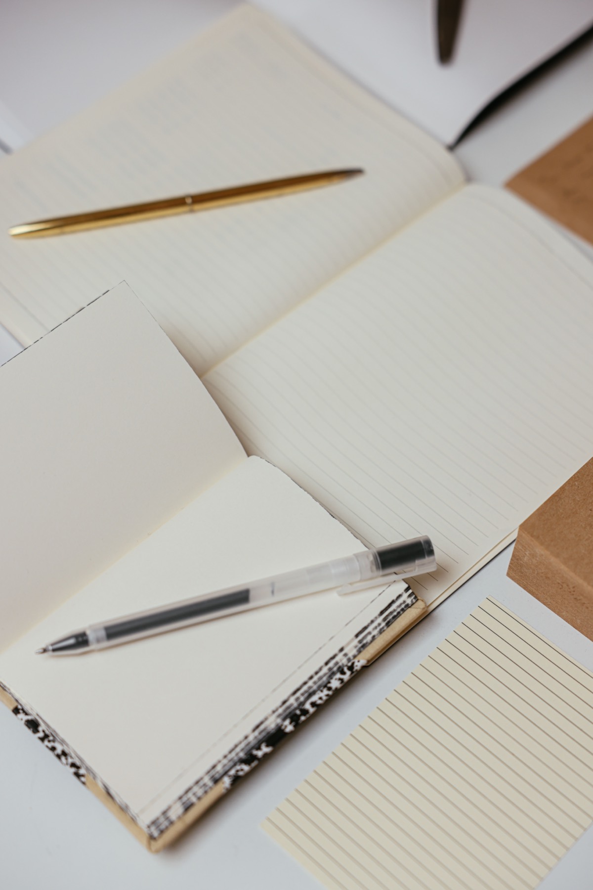 Open notebooks with a gold pen and a gel pen